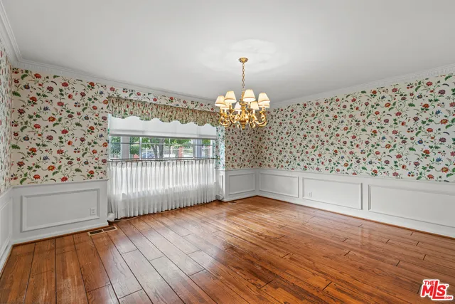 a view of a livingroom with wooden floor and a large window