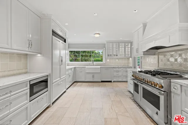 a kitchen with granite countertop a stove top oven and cabinets