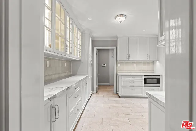 a kitchen with white cabinets and refrigerator