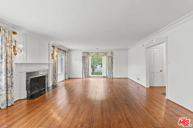 a view of empty room with wooden floor and fireplace