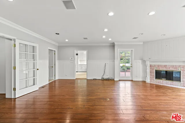 a view of empty room with wooden floor and fireplace