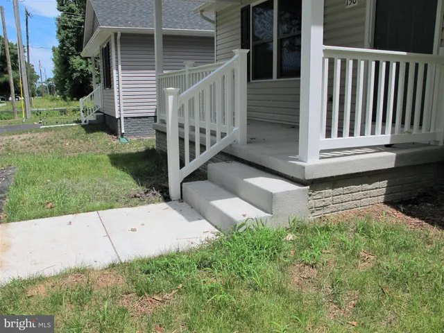 a view of a house with backyard and porch