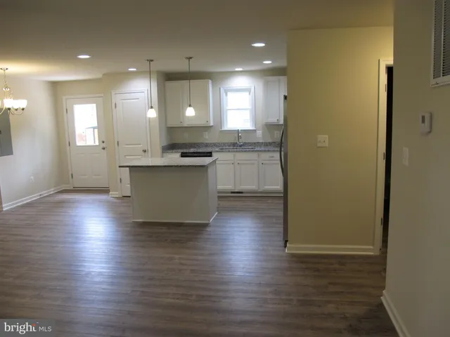 a kitchen with kitchen island wooden floors and stainless steel appliances