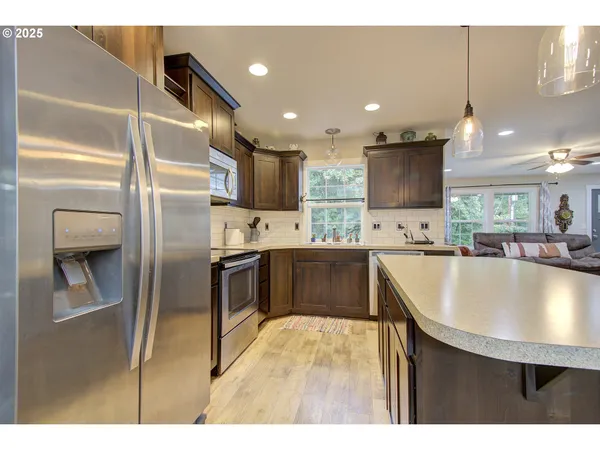 a kitchen with kitchen island a counter top space a sink stainless steel appliances and cabinets