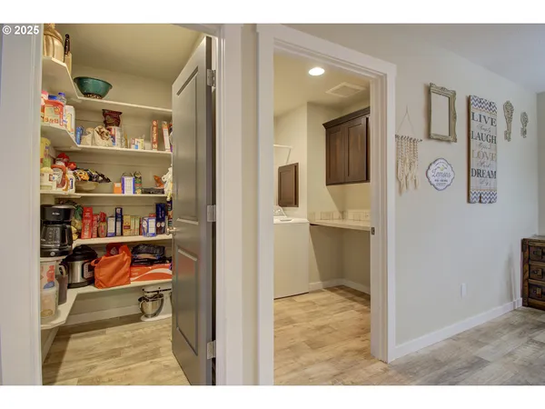 a kitchen with stainless steel appliances kitchen island granite countertop a table chairs sink and cabinets
