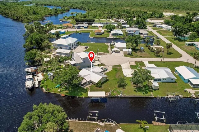 an aerial view of a house with a garden and lake view