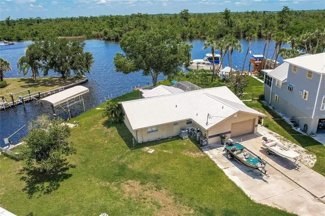 an aerial view of a house with a garden and lake view