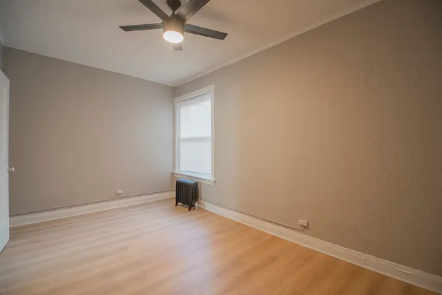 an empty room with a ceiling fan and a window