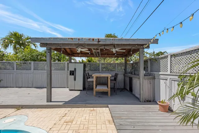 a patio with wooden floor a yard a table and chairs
