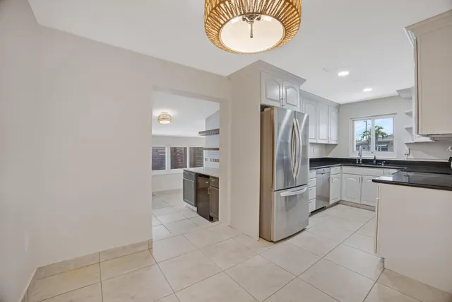 a kitchen with a refrigerator sink and cabinets