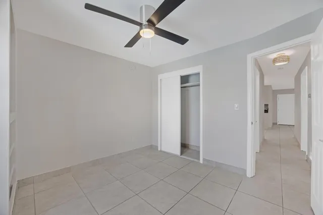 an empty room with chandelier fan