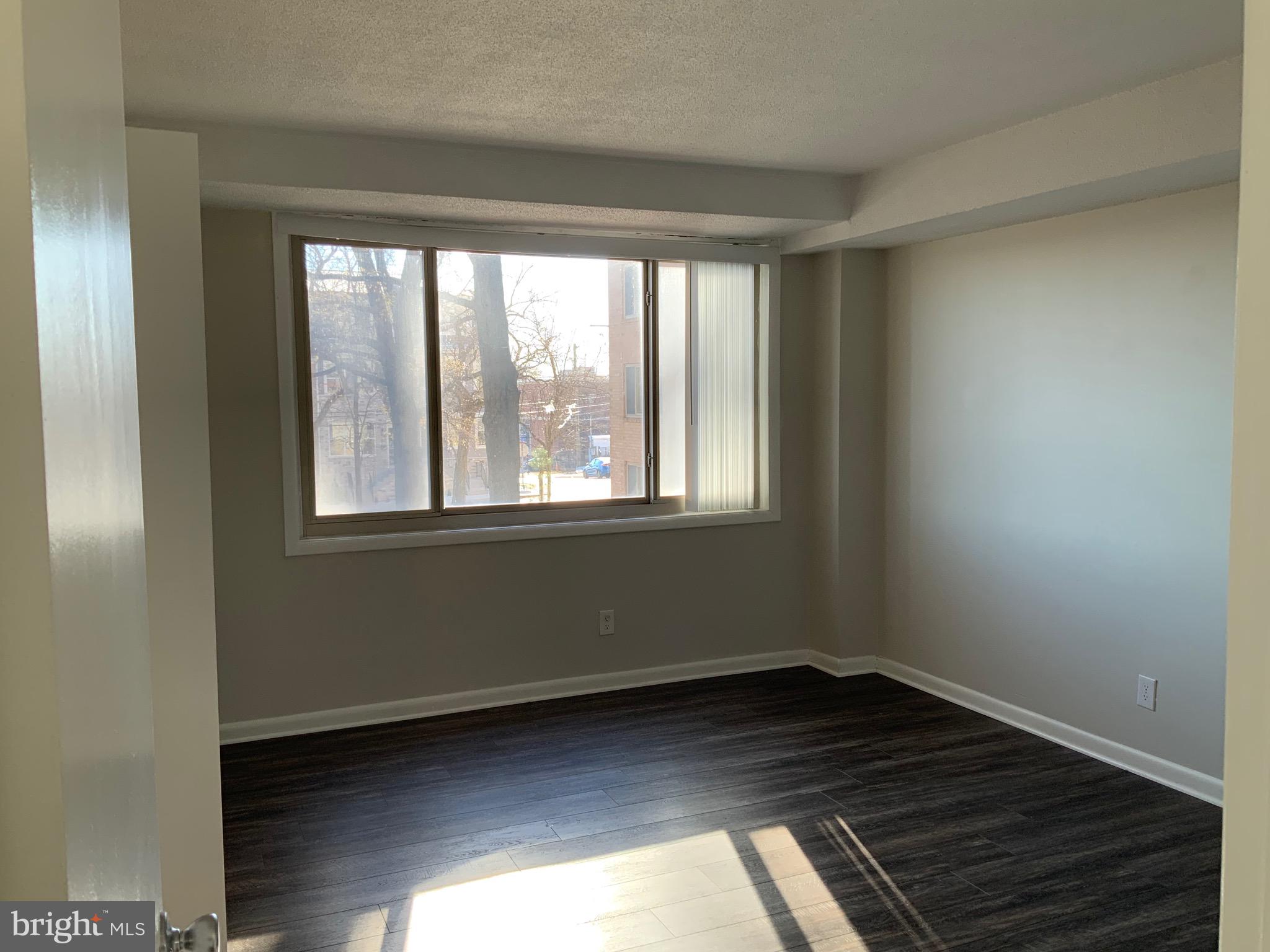 4410 Oglethorpe Street, Unit 201 Hyattsville, MD 20781 - Photo 11 of 13 a view of an empty room with wooden floor and a window