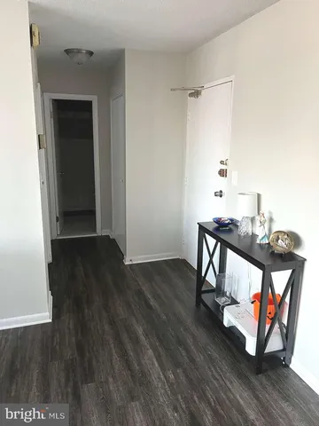 a view of a hallway with wooden floor and furniture