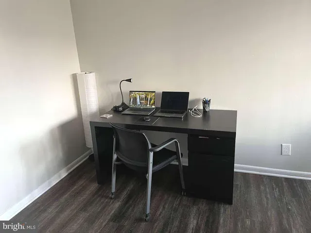 a view of a workspace with furniture and wooden floor
