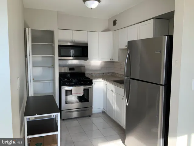 a kitchen with a refrigerator and a stove