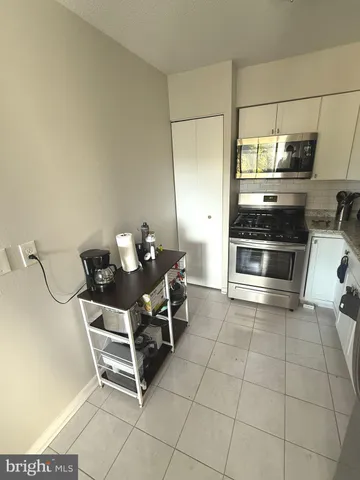a room with a chair and white cabinets