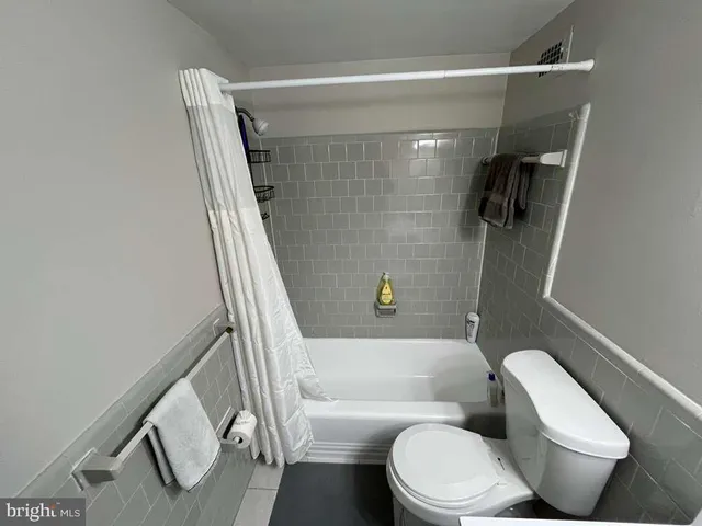 a white toilet sitting next to a bath tub