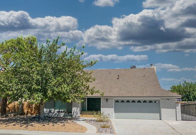 an aerial view of a house with a yard and covered with trees