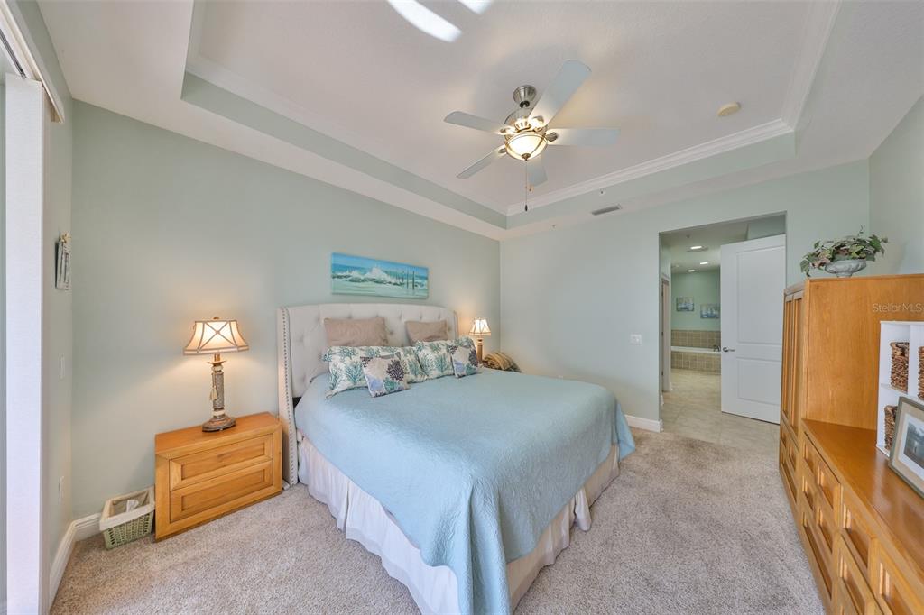 1030 Bellasol Way, Unit 302 Apollo Beach, FL 33572 - Photo 16 of 39 a bedroom with a bed and a chandelier
