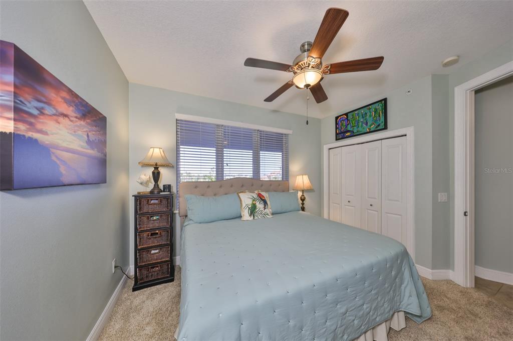 1030 Bellasol Way, Unit 302 Apollo Beach, FL 33572 - Photo 24 of 39 a bedroom with a bed and a chandelier