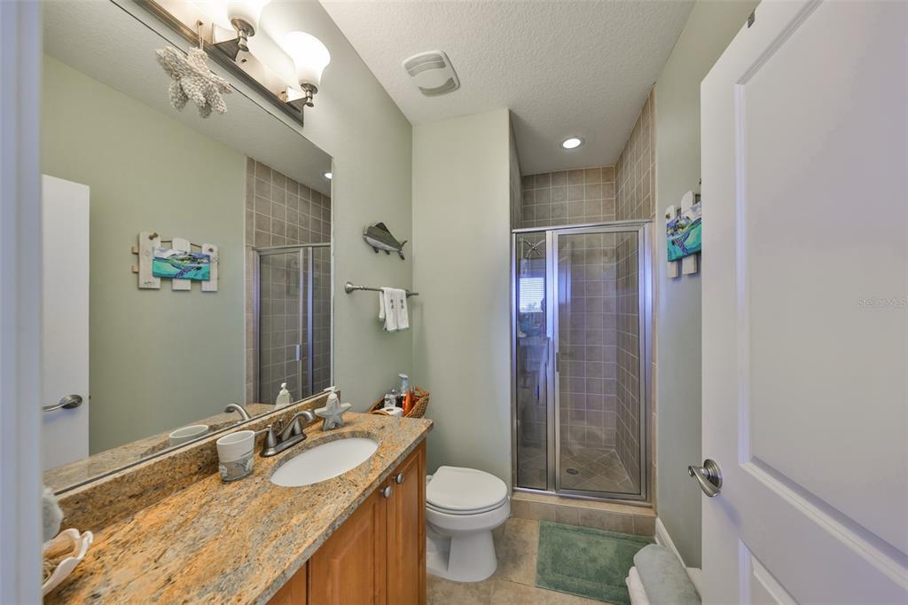 1030 Bellasol Way, Unit 302 Apollo Beach, FL 33572 - Photo 26 of 39 a bathroom with a granite countertop sink toilet and shower