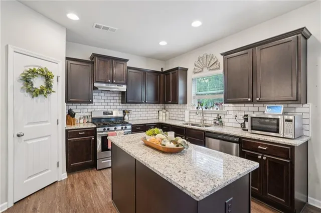 a kitchen with stainless steel appliances granite countertop wooden cabinets stove and refrigerator