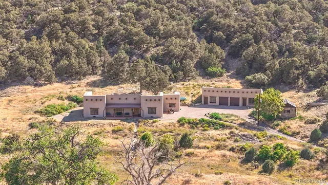 a view of a large building with large trees and plants