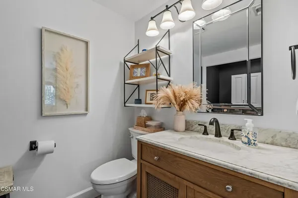 a bathroom with a granite countertop sink a toilet and mirror