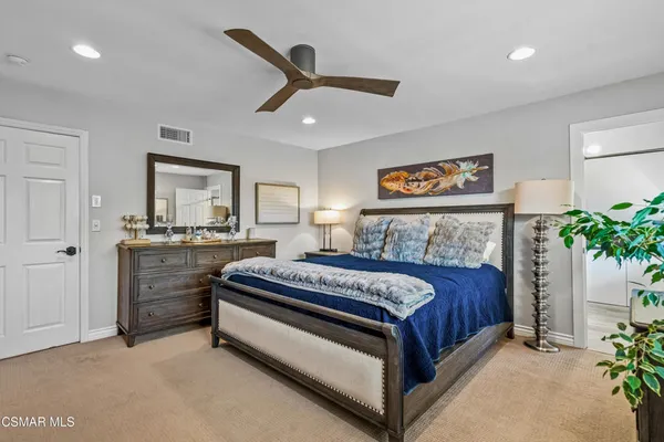 a spacious bedroom with a bed and a potted plant