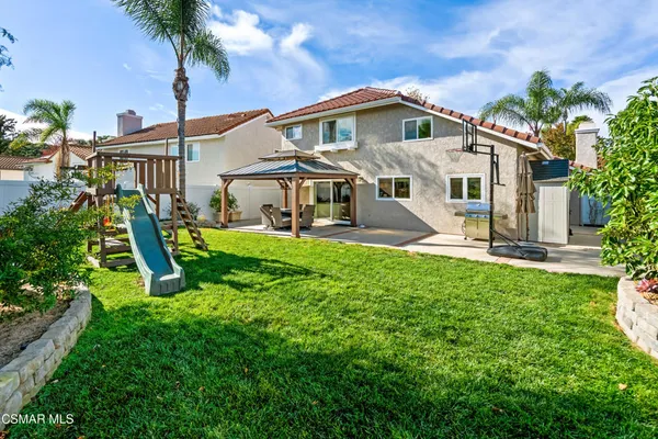 a front view of a house with a yard and potted plants