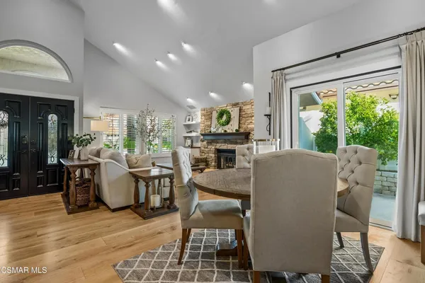 a dining room with furniture a fireplace and wooden floor