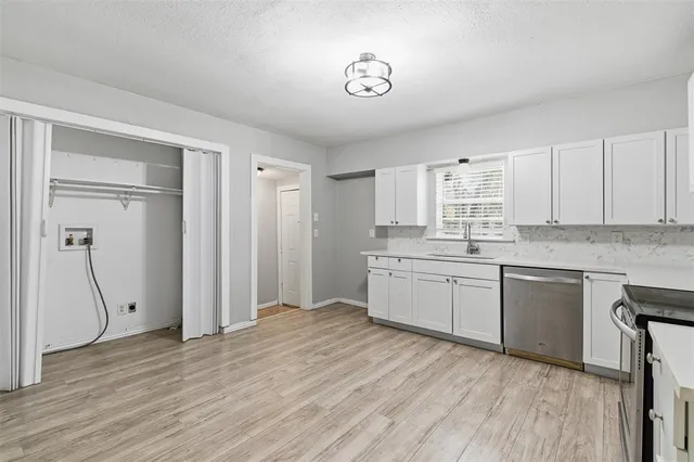 a kitchen with a refrigerator a sink and cabinets