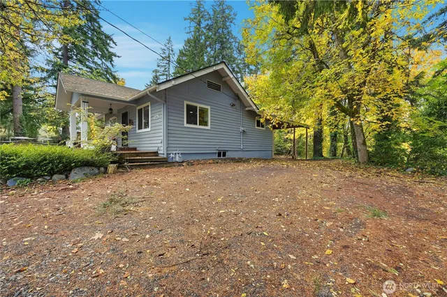 a view of a house with a yard and large tree