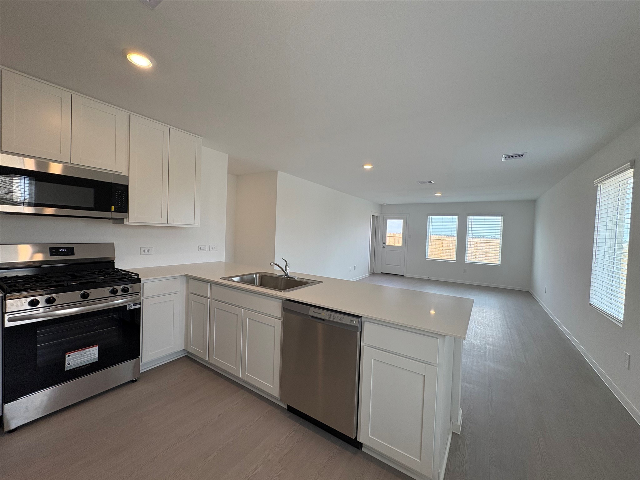 5727 Little Redwing Drive Baytown, TX 77521 - Photo 4 of 25 a kitchen with stainless steel appliances granite countertop a stove a sink and a microwave