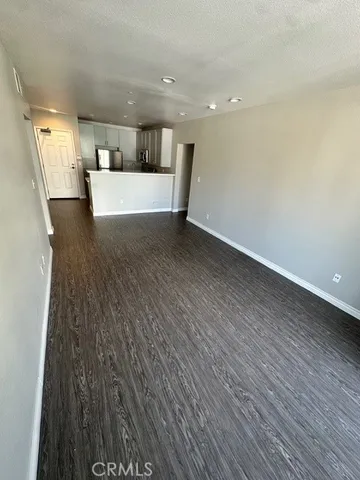 a view of a big room with wooden floor and more windows