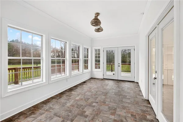 a view of an empty room with wooden floor and windows