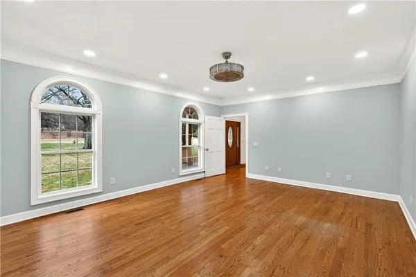 a view of a hallway with wooden floor and staircase