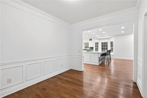 a living room with furniture and kitchen view with wooden floor