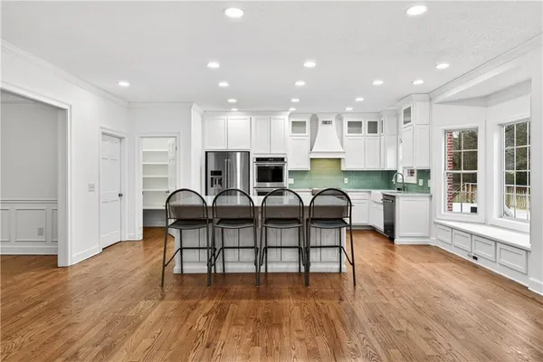 a kitchen with stainless steel appliances granite countertop a stove top oven a sink and a refrigerator
