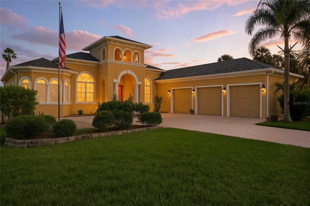 a front view of a house with a garden and trees