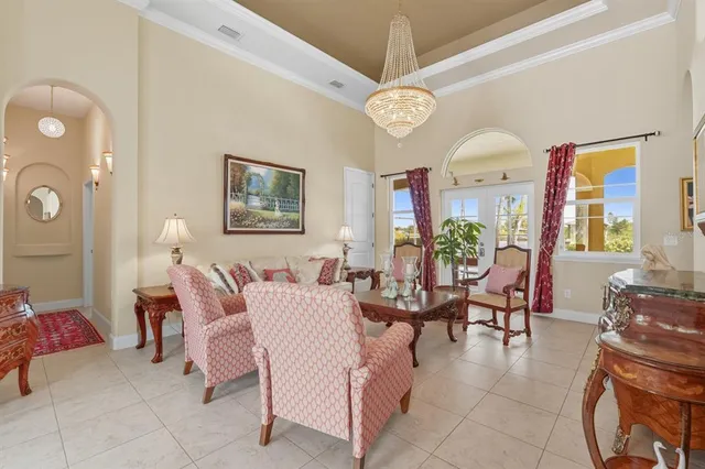 a living room with furniture chandelier and a large window