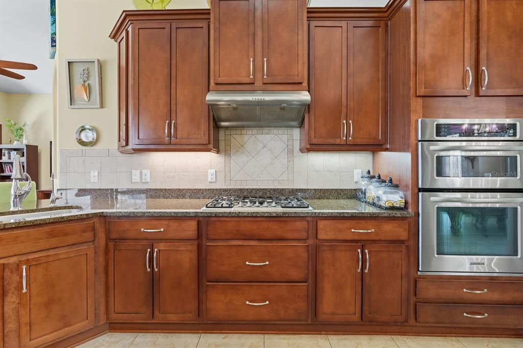 430 Lambert Avenue Flagler Beach, FL 32136 - Photo 23 of 63 a kitchen with granite countertop wooden cabinets and stainless steel appliances