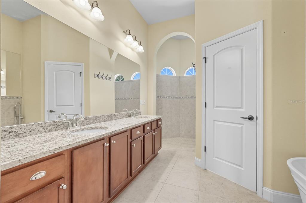 430 Lambert Avenue Flagler Beach, FL 32136 - Photo 35 of 63 a spacious bathroom with a granite countertop sink mirror and a