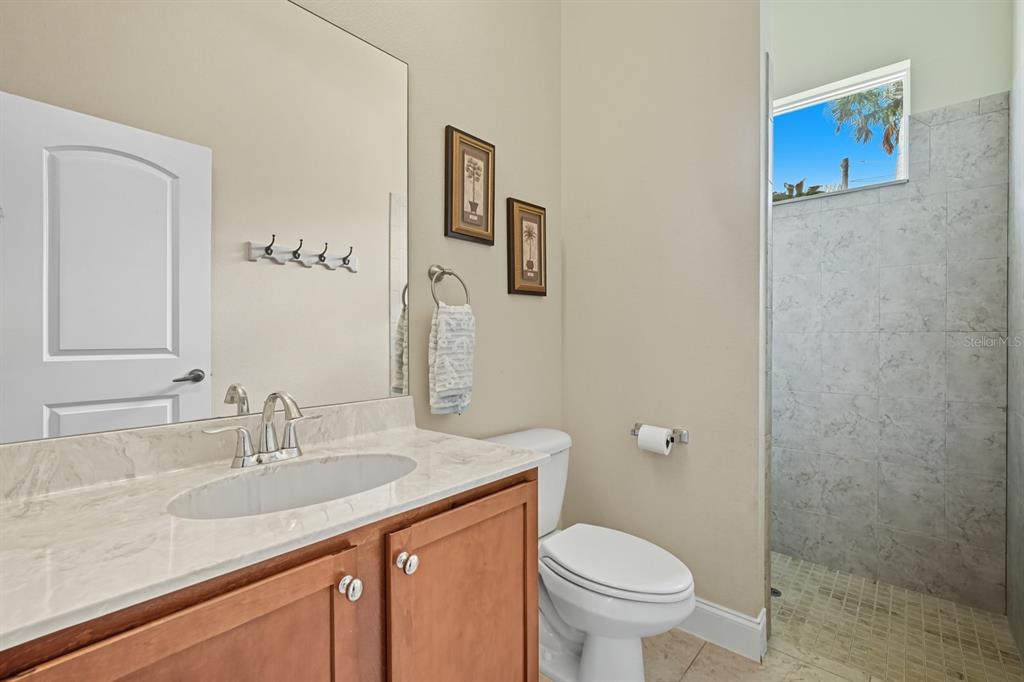 430 Lambert Avenue Flagler Beach, FL 32136 - Photo 43 of 63 a bathroom with a granite countertop toilet a sink and a mirror