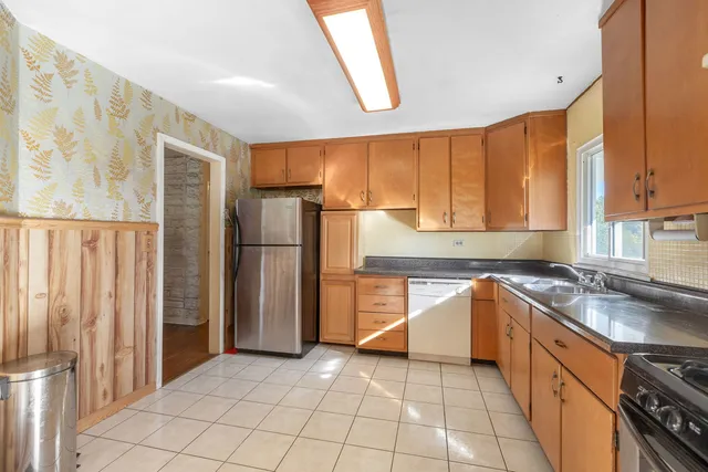 a kitchen with stainless steel appliances granite countertop a refrigerator and a sink