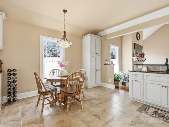 a dining room filled chandelier and kitchen view