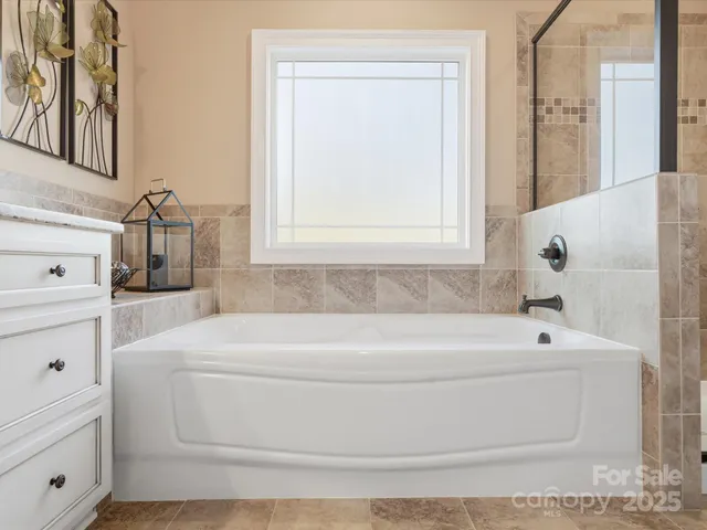 a bathroom with a bathtub and mirror
