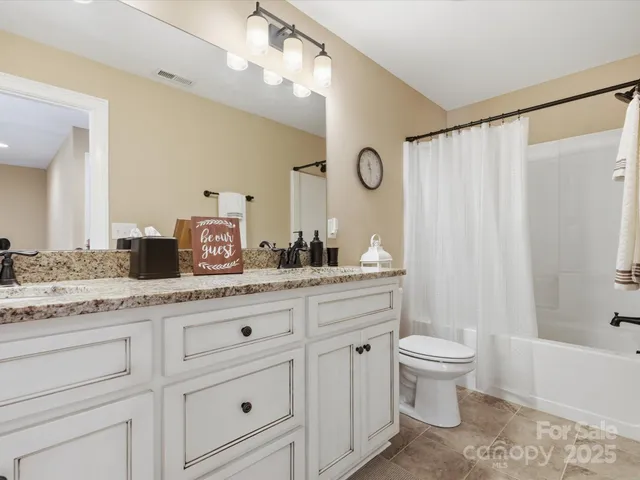 a bathroom with a granite countertop sink a toilet and a bathtub