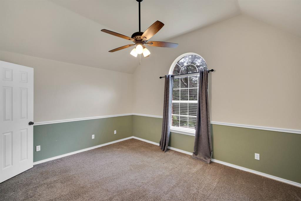 1907 Timber Ridge Court Cedar Hill, TX 75104 - Photo 23 of 30 Vaulted ceiling bedroom featuring a ceiling fan with light fixture, arched window, two-tone wall treatment, and carpet flooring
