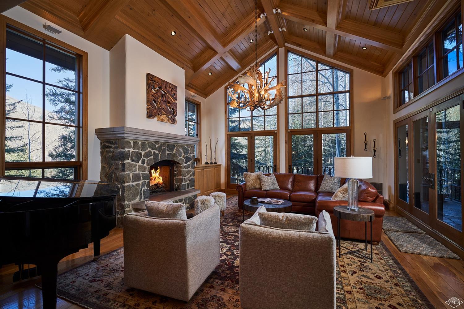 a living room with furniture a fireplace and a floor to ceiling window